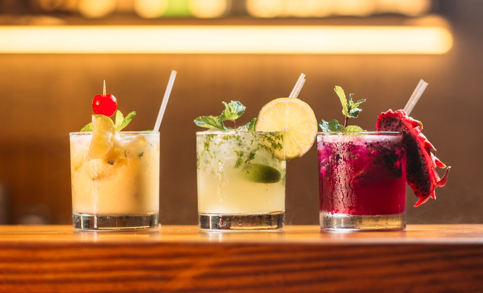 Drei bunte Cocktails an der Bar